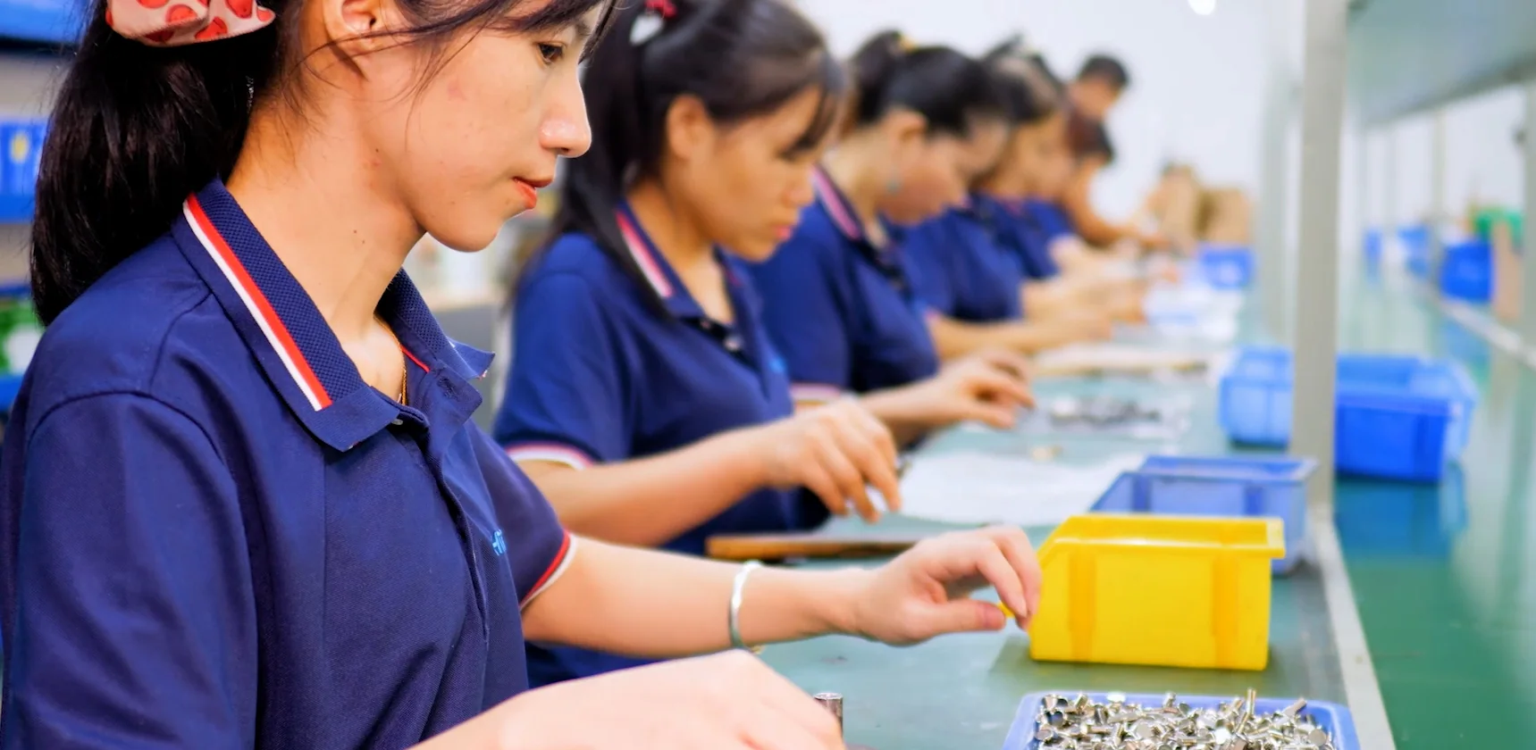 Personal de HSP trabajando con componentes de herrajes industriales en la línea de montaje