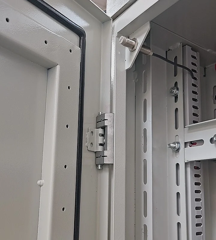 Puerta abierta de un gabinete de control con bisagra, estructura interior y espacio para cableado